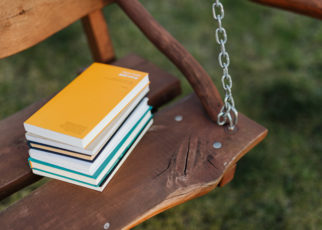 Stack of books placed on seat of wooden swing